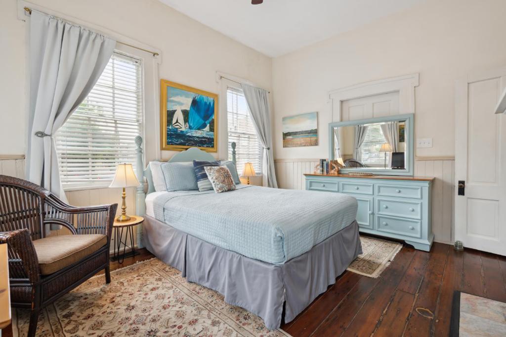 a bedroom with a bed and a dresser and a mirror at Charming Savannah Duplex Courtyard Parking in Savannah