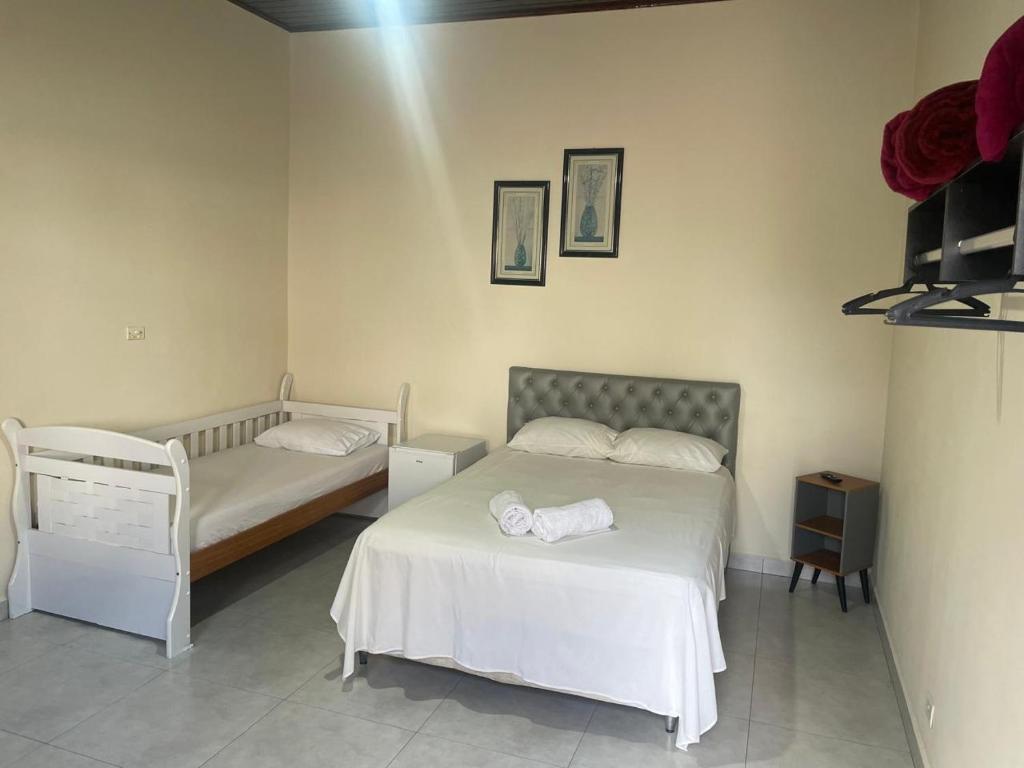 a bedroom with two beds in a room at Família Bonette in Cananéia