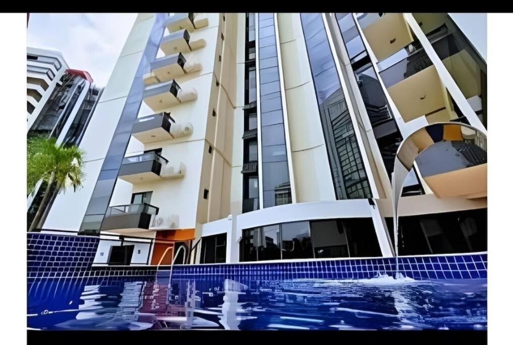 een gebouw met een zwembad voor een gebouw bij Studio Urbano Sun Square hotel in Goiânia