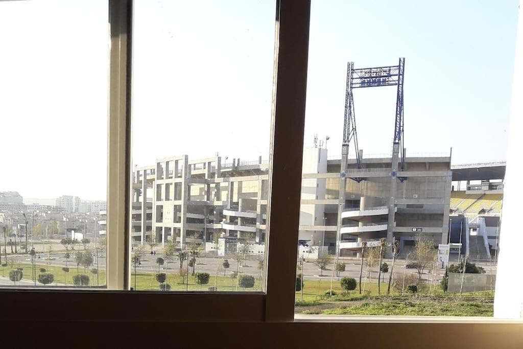 een raam met uitzicht op een groot gebouw bij Le Joyau du Parc Tanger Vue Panoramique Parking Gratuit in Tanger