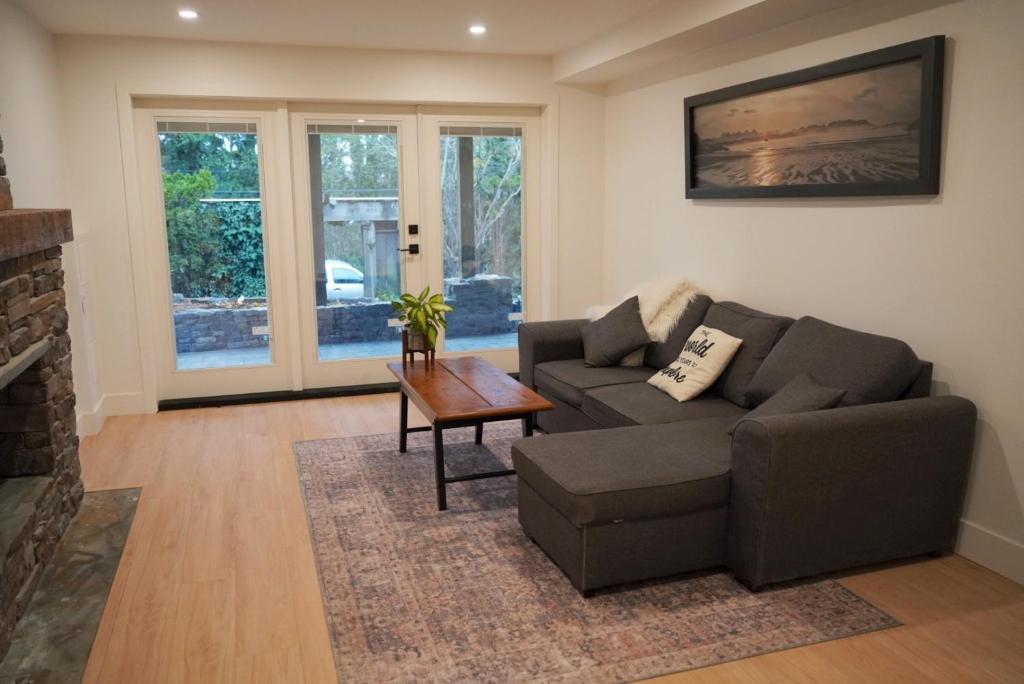 a living room with a couch and a table at Spacious Forested Garden Suite in North Vancouver