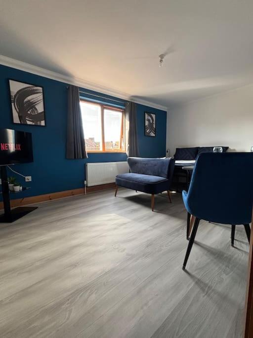 a living room with a piano and blue walls at Vibrant City Center Studio Apartment 6a in Norwich