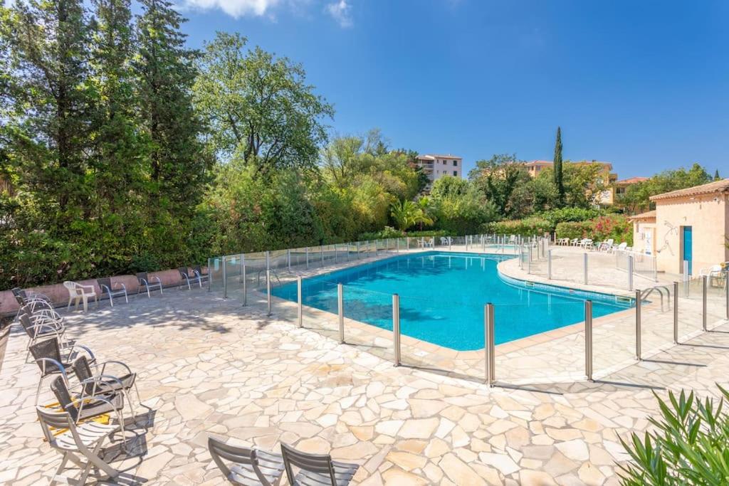 une grande piscine avec des chaises dans l'établissement Joli 32m2, piscine, parking, Wifi, à Fréjus