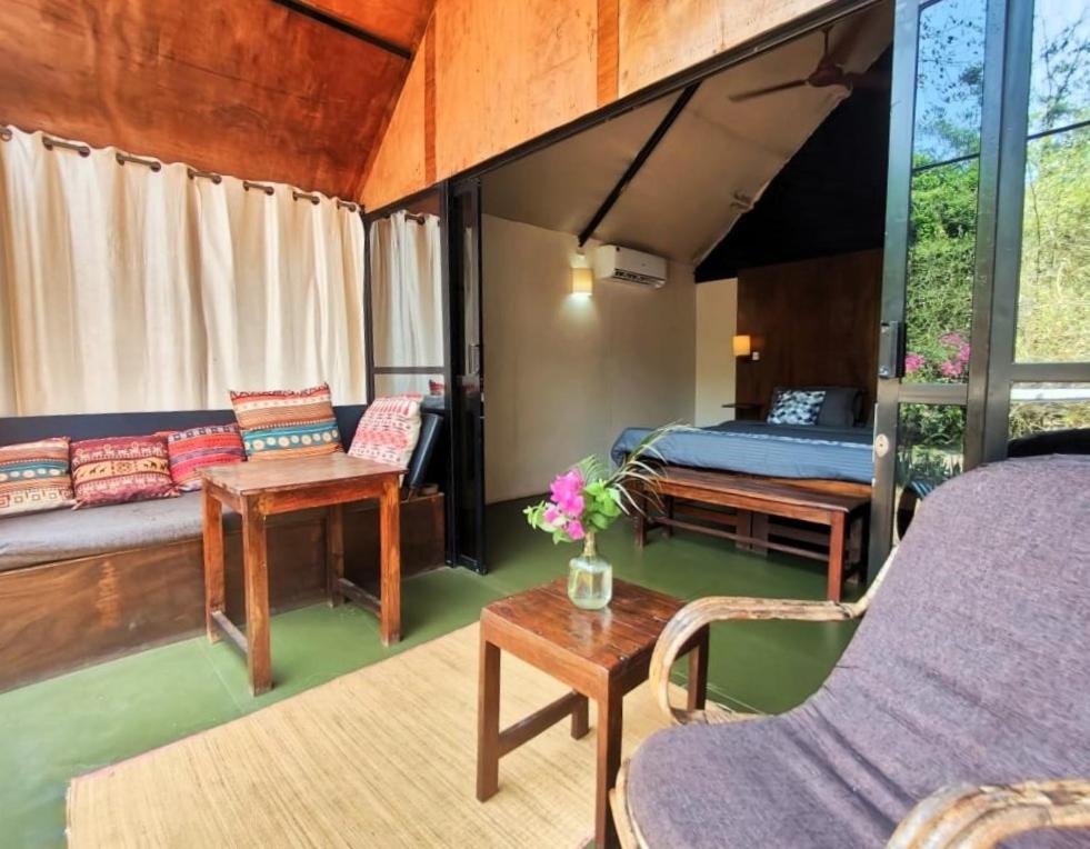a room with a couch and a bed and a table at Nada Brahma Patnem Beach in Patnem