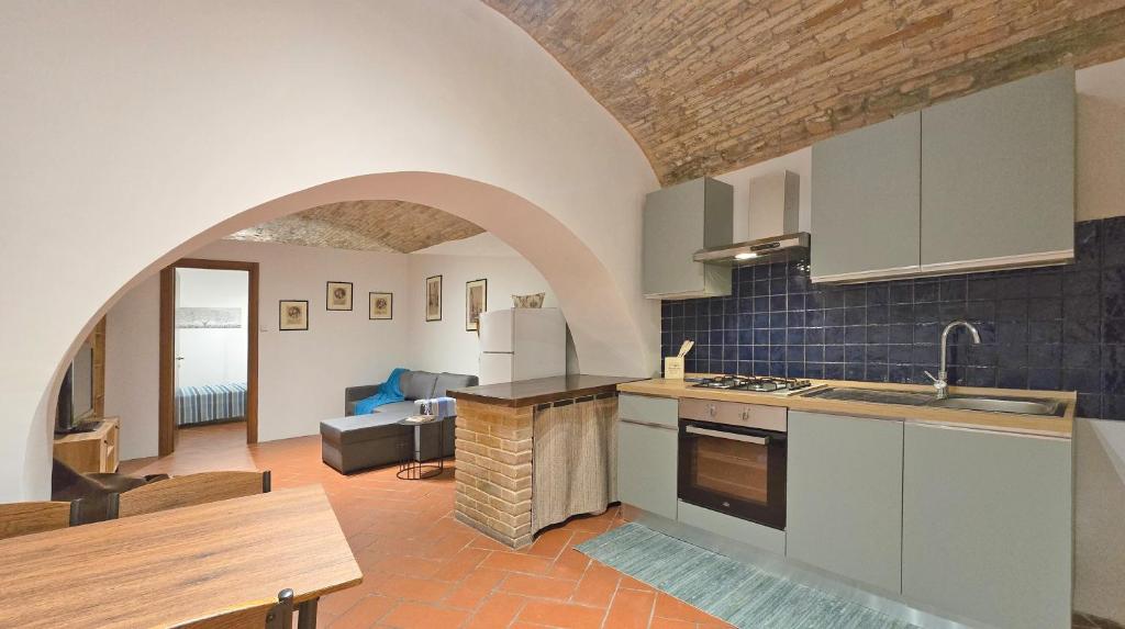 una cucina e un soggiorno con arco in un edificio di Adiacente Piazza del Mercato a Spoleto