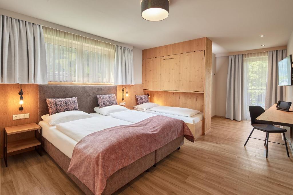سرير أو أسرّة في غرفة في HOTEL SONNBLICK Kaprun, Salzburg - including Summer Card