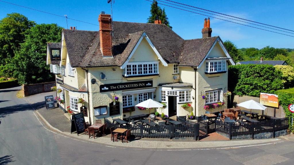 a inn with tables and chairs in front of it at The Cricketers Inn in Winchester