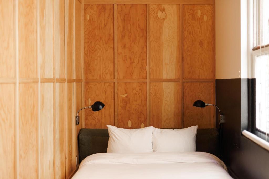 a bedroom with a bed with two lamps on it at The Clyde Hotel Portland by Kasa Living in Portland