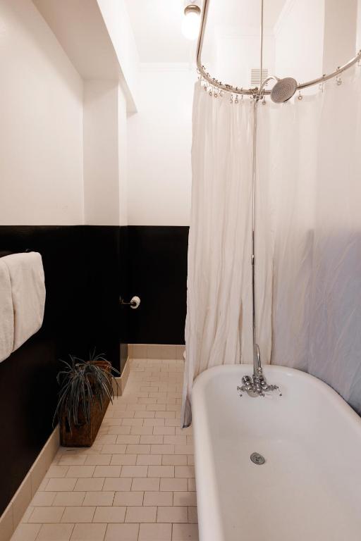 a bathroom with a white tub and a shower at The Clyde Hotel Portland by Kasa Living in Portland