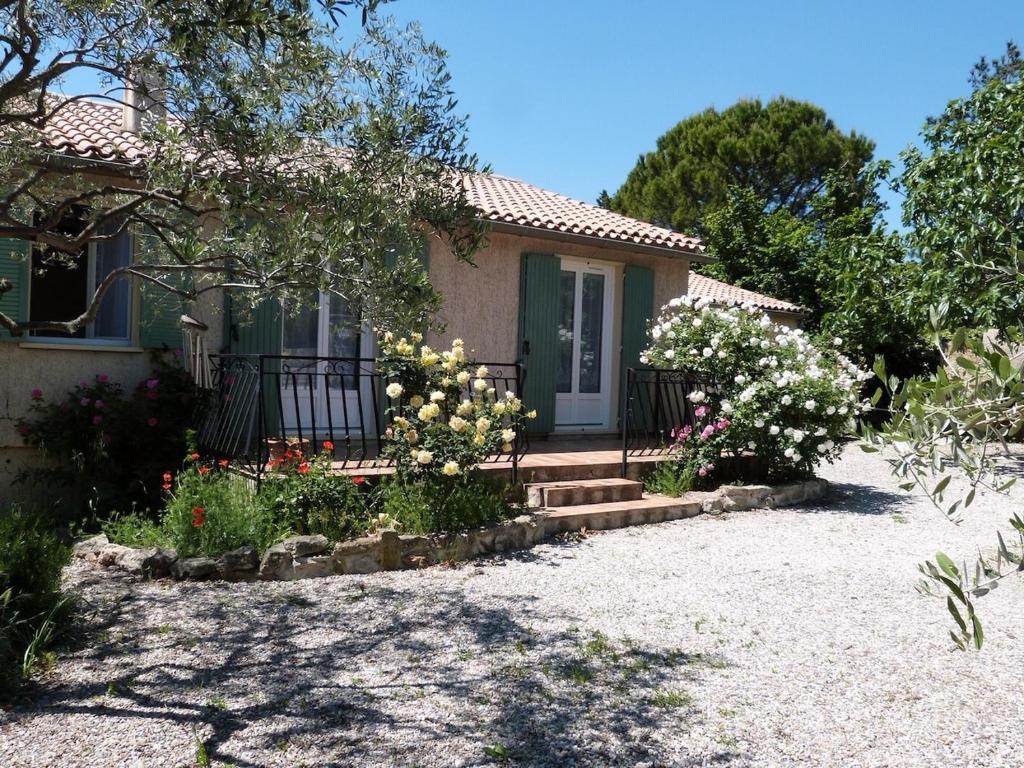 une petite maison avec des fleurs devant elle dans l'établissement Villa Provence proche du Mont Ventoux avec piscine et jardin, à Caromb