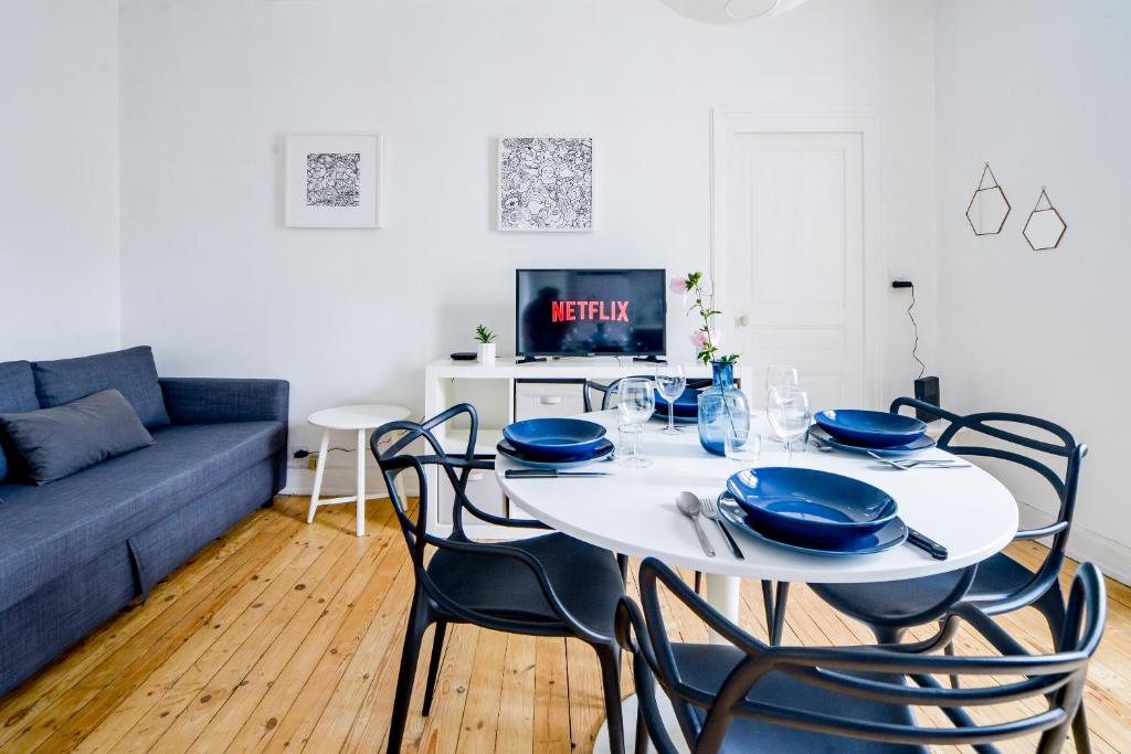 un salon avec une table avec des chaises et un canapé dans l'établissement Le Paradis D'Oé - Hypercentre - Netflix, à Tours