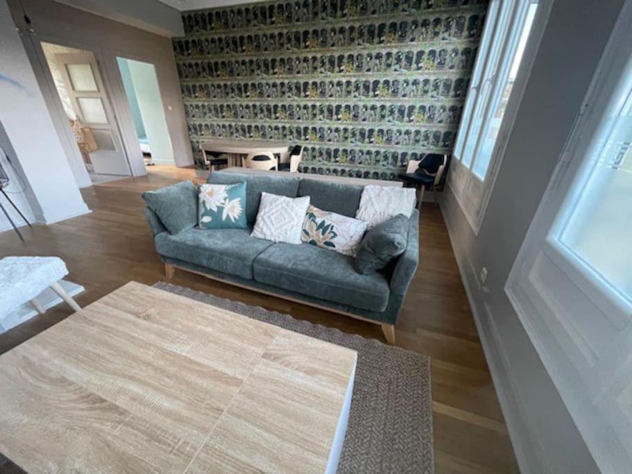 un salon avec un canapé bleu et un tapis dans l'établissement Appartement rénové hyper-centre, à Saint-Nazaire