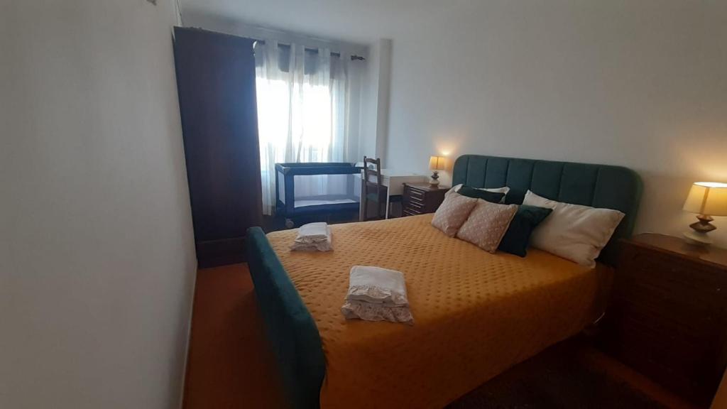 a bedroom with a bed with a green headboard at GreenSea II in Peniche