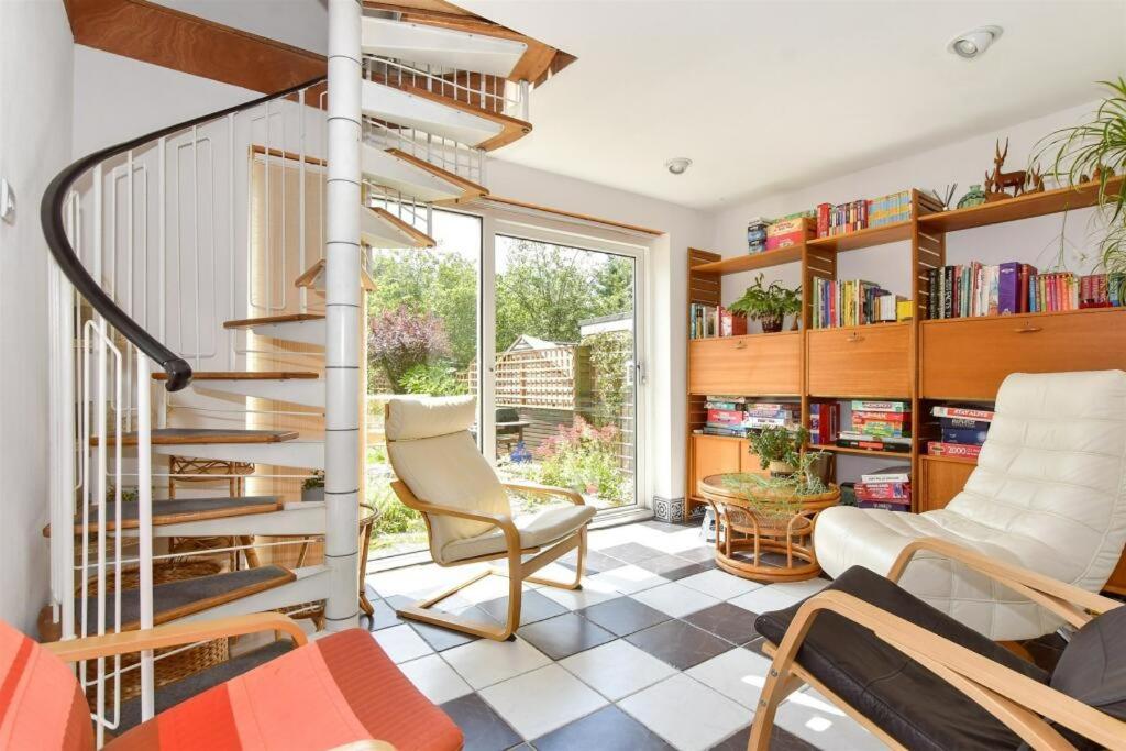 una sala de estar con una escalera de caracol y sillas en Scandi inspired holiday home Brentwood, en Brentwood