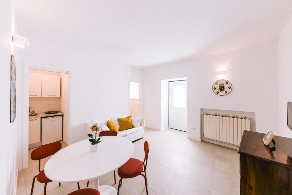 un soggiorno bianco con tavolo e sedie bianchi di Casa Don Matteo a Scala