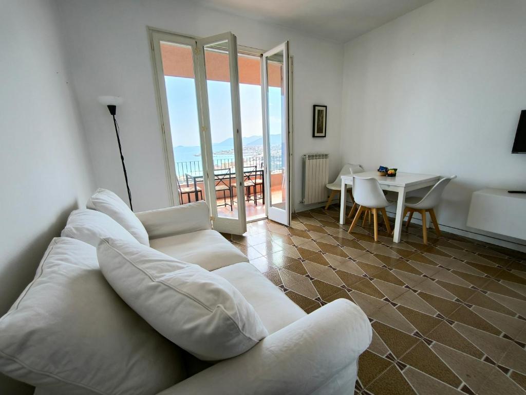 a living room with a white couch and a table at Panorama - By Ligooria in Pietra Ligure