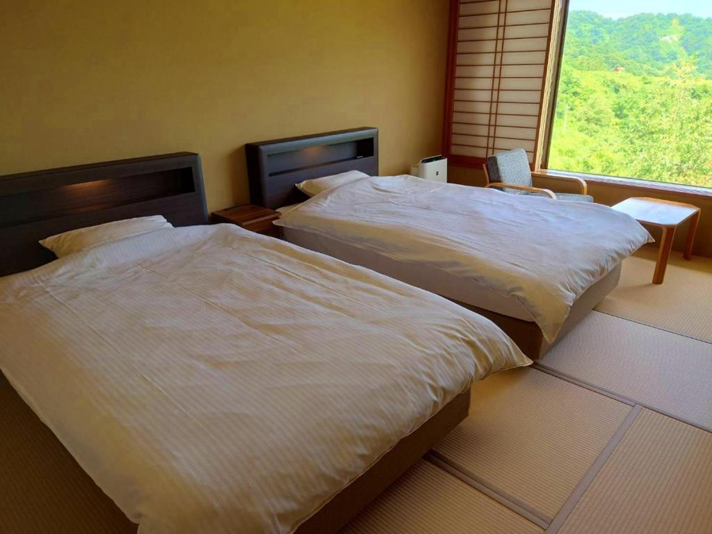Postel nebo postele na pokoji v ubytování Sasakura onsen Ryuunso