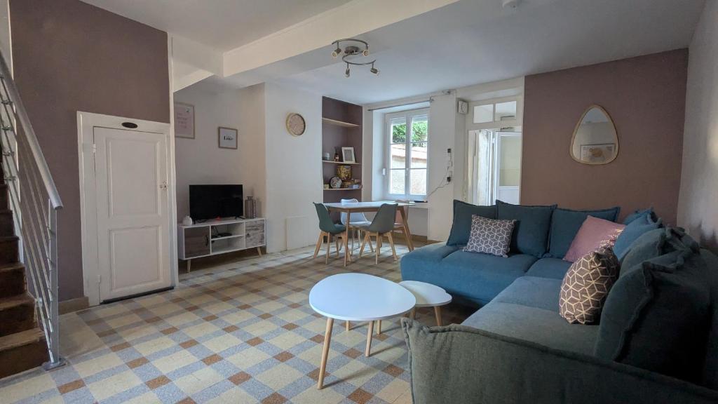 un salon avec un canapé bleu et une table dans l'établissement le gîte de la ruelle, à Neuvy-sur-Loire