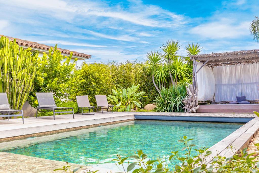 - une piscine dans un jardin avec 2 chaises et une maison dans l'établissement Villa Mara, à Lecci