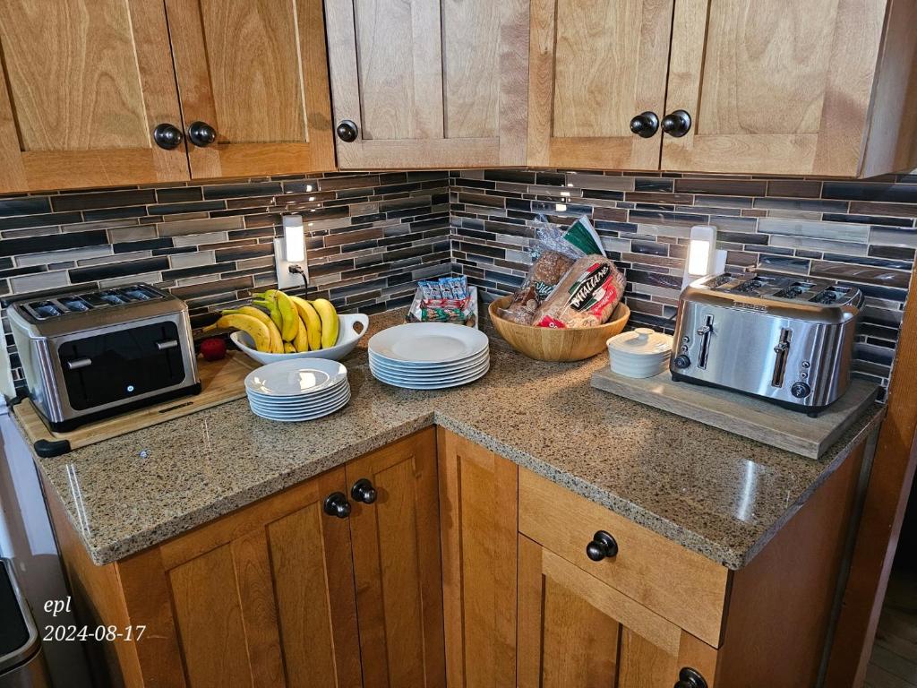 a kitchen counter with a bowl of bananas and a microwave at Small Town Bound Inn in Montague