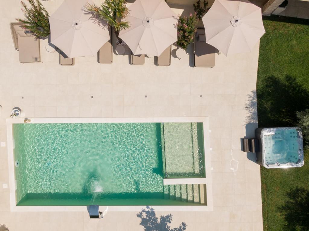 an overhead view of a swimming pool with umbrellas at Villa Dolce Vita in Međugorje