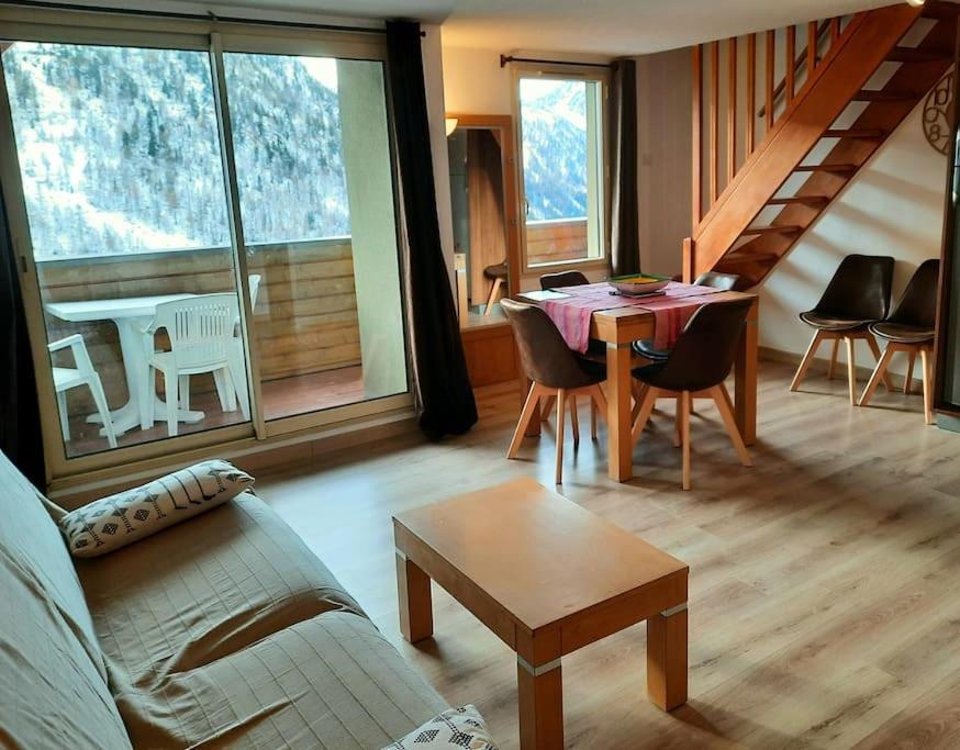 un salon avec un canapé et une table avec des chaises dans l'établissement Isola 2000 duplex 7P vue pistes dernier etage, à Isola 2000