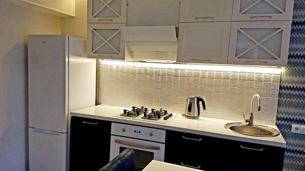 a kitchen with a sink and a stove and a refrigerator at Very beautiful apartment in Komitas avenue in Yerevan