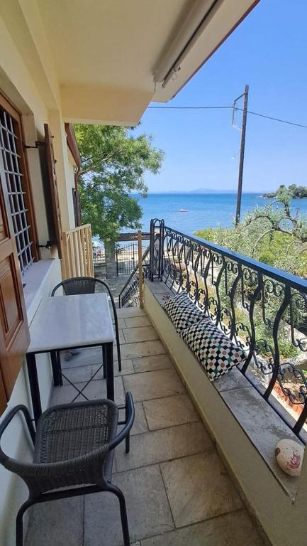 a balcony with two chairs and a table and the ocean at Homico 2 Lefokastro in Lefokastro