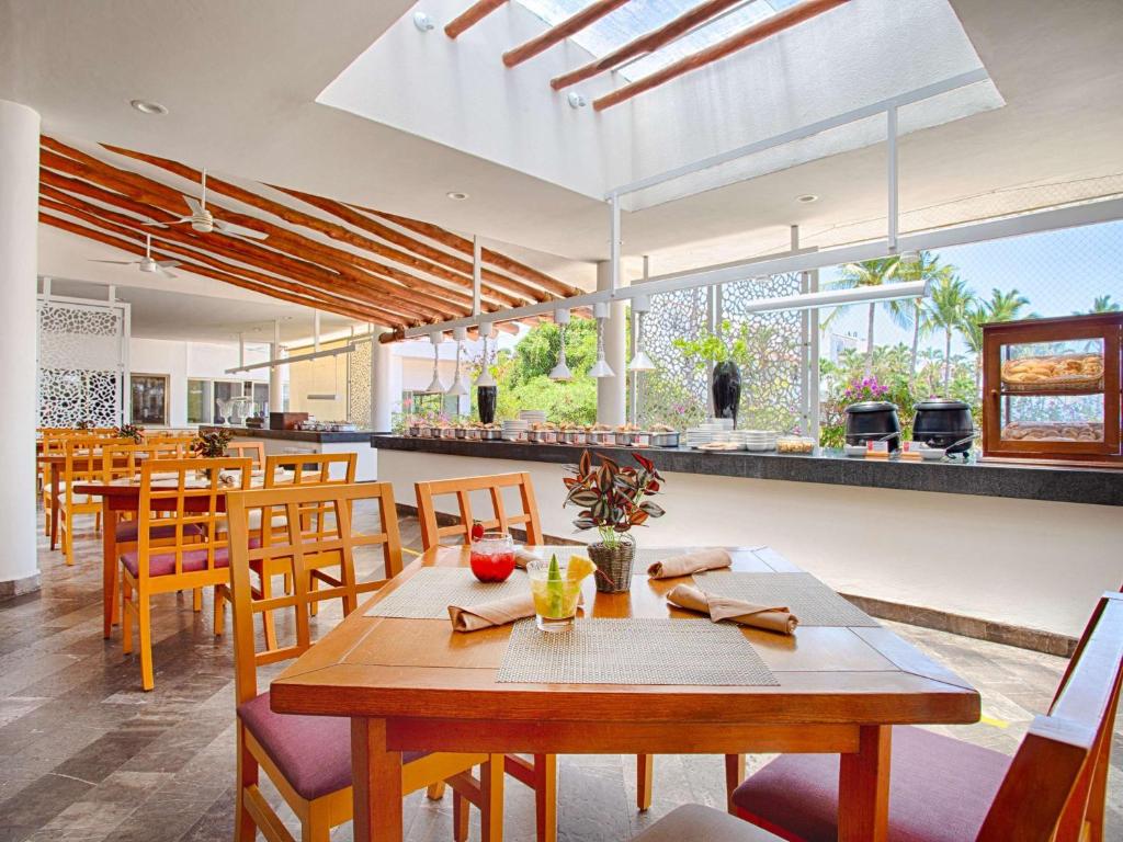 a dining room with a table and some chairs at Marival Emotions Resort & Suites Riviera Nayarit by Mercure in Nuevo Vallarta
