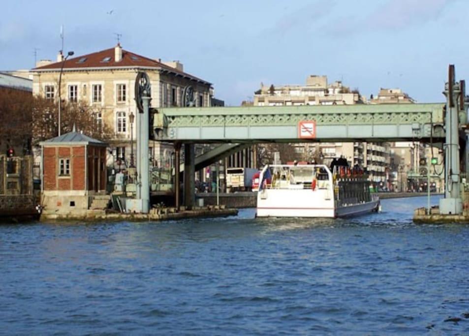 un bateau est amarré à côté d'un pont sur une rivière dans l'établissement Charmant Studio au Cœur de Paris Cosy Studio Paris, à Paris