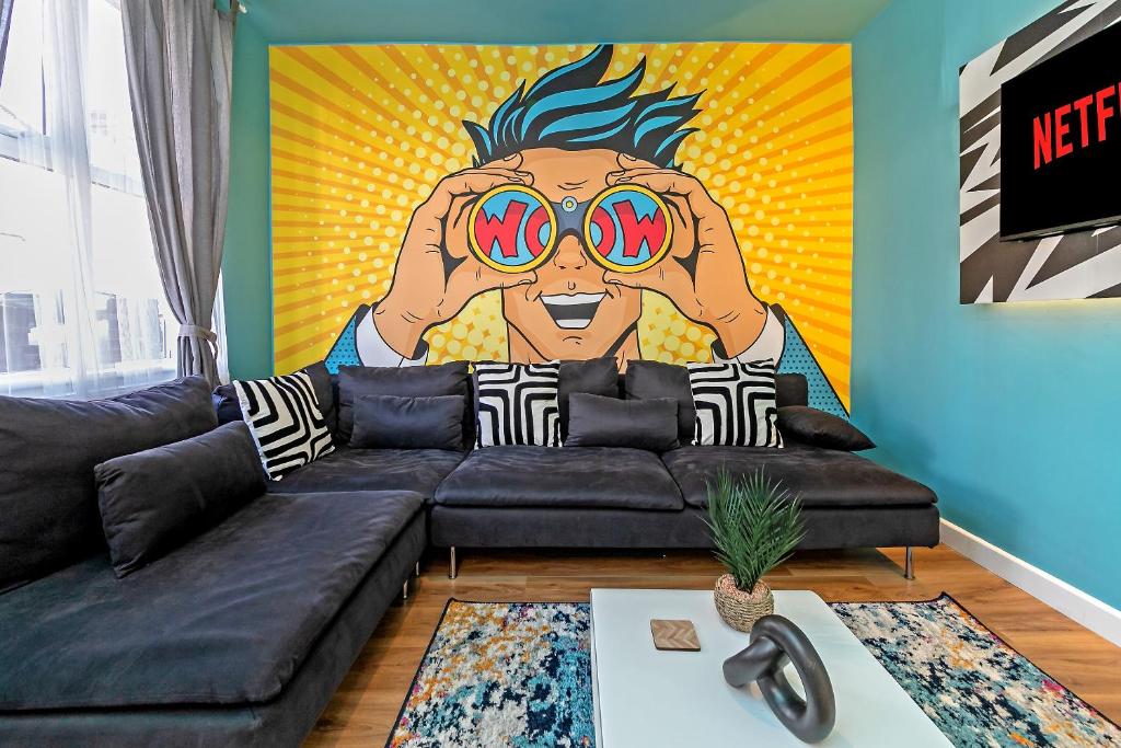 a living room with a couch and a painting of a man with sunglasses at Exclusive Town Centre Home, FREE Parking, Walk to TRAIN STATION, Near AIRPORT, LUXURY Stay, GARDEN, POP ART Decor in Luton