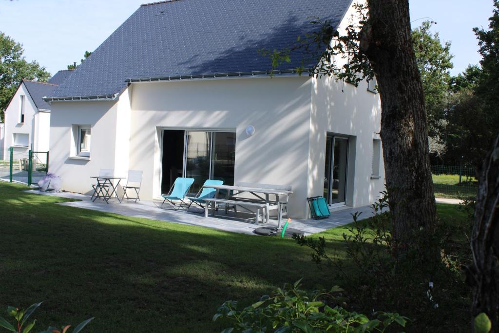 a white house with two chairs and a table at La maison de Qui miac in Quimiac