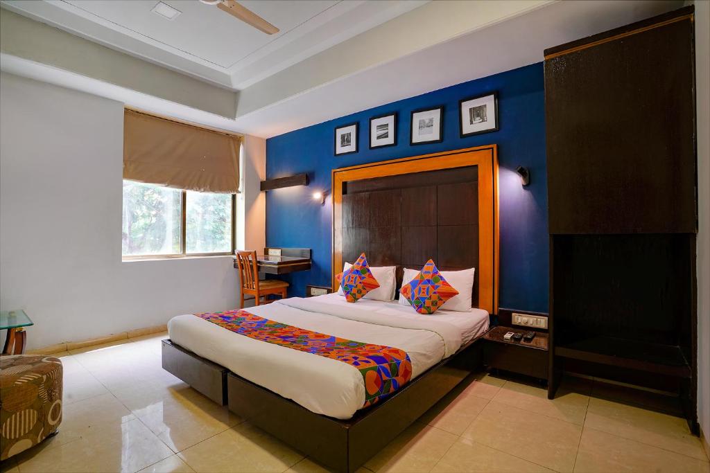 a bedroom with a large bed with blue walls at Via Manas Residency in Mumbai