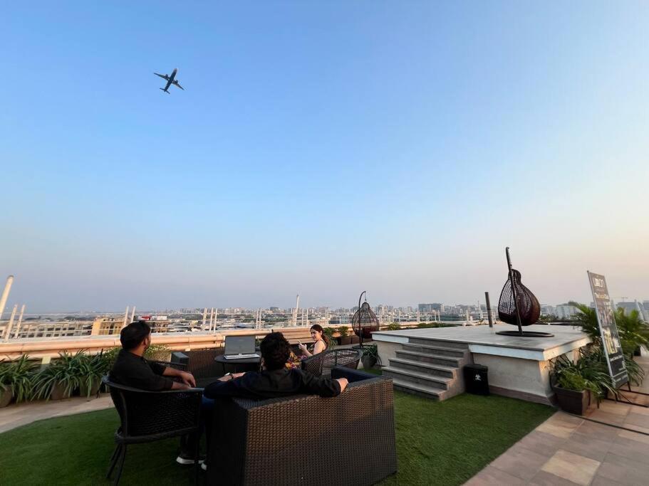 un gruppo di persone seduti sopra un edificio di 3BHK Apartment Santacruz Mumbai, 104 a Mumbai
