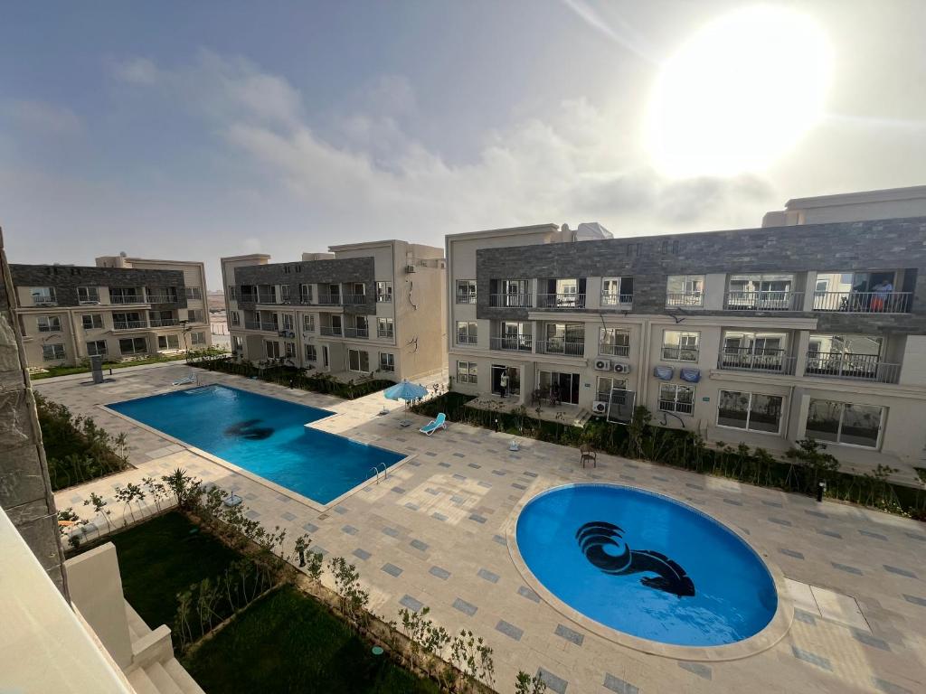 eine Luftaufnahme eines Apartmentkomplexes mit zwei Swimmingpools in der Unterkunft Elite North coast Seaview resort in El-Alamein