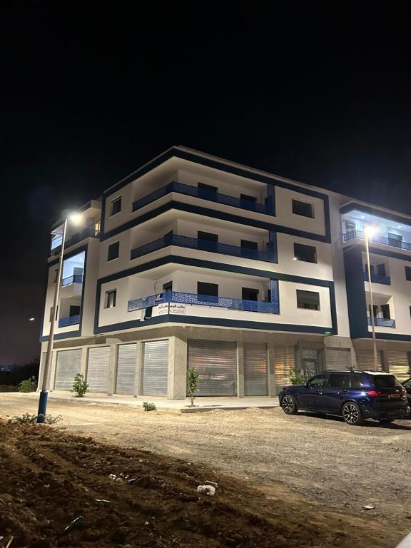 a building with a car parked in front of it at Nour Beach Cabo in Martil