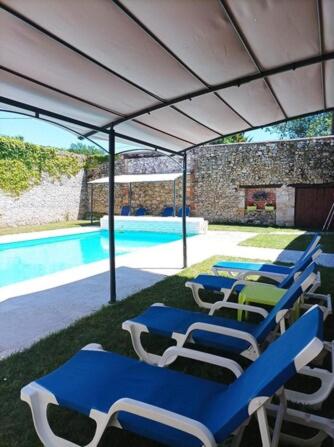 un groupe de chaises bleues et blanches et une piscine dans l'établissement Teyssie Cottage, à Pailloles