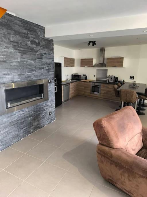 un salon avec un canapé et une cuisine dans l'établissement chez Julien, à Chavot-Courcourt