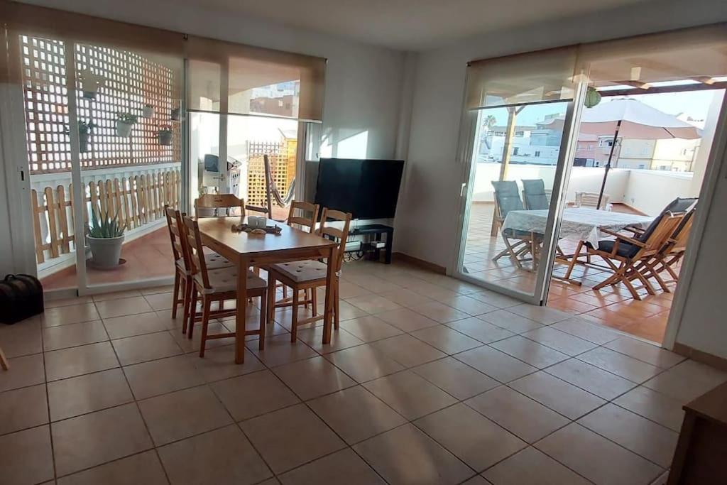 a dining room with a table and chairs and a balcony at Apartment happy place mit Meerblick in Alcalá