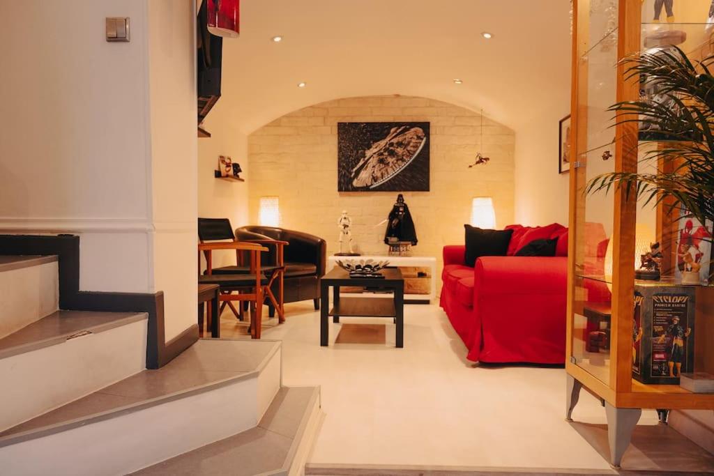 Una sala de estar con un sofá rojo y sillas. en Rouen - La Maison Star Wars - Marvel, en Rouen