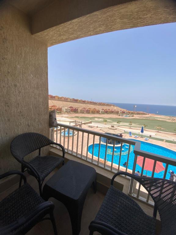 アインソフナにあるPorto Sokhna Island 1 families onlyのプールの景色を望むバルコニー(椅子付)