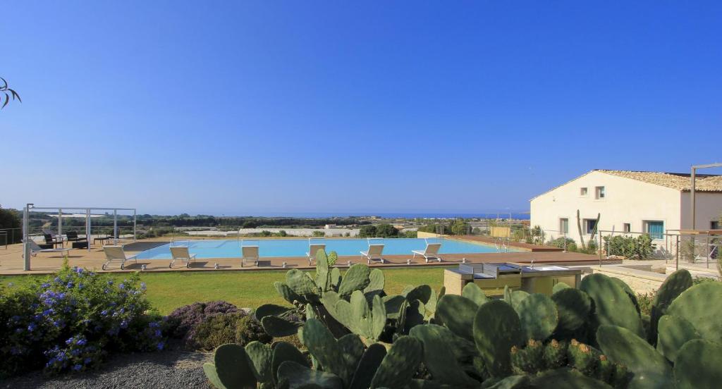 a view of the pool from the garden of a villa at Petrantica Resort in Marina di Ragusa