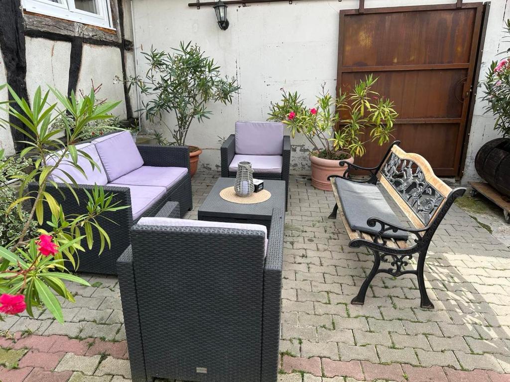 patio z krzesłami, stołami i roślinami w obiekcie Gîte au Giessen - Loft w mieście Biesheim