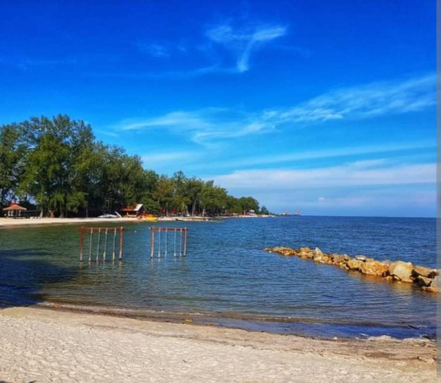 una playa con un grupo de sillas en el agua en Tasik Dedap, en Sepang