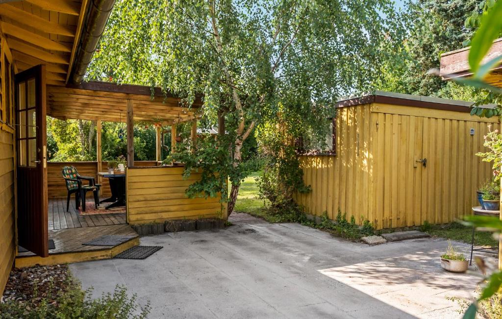 a backyard with a wooden fence and a table at 3 Bedroom Gorgeous Home In Jægerspris in Jægerspris