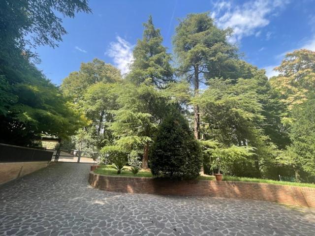 un giardino con alberi e un muro di mattoni e alberi di SIEPELUNGA B&B a Bologna