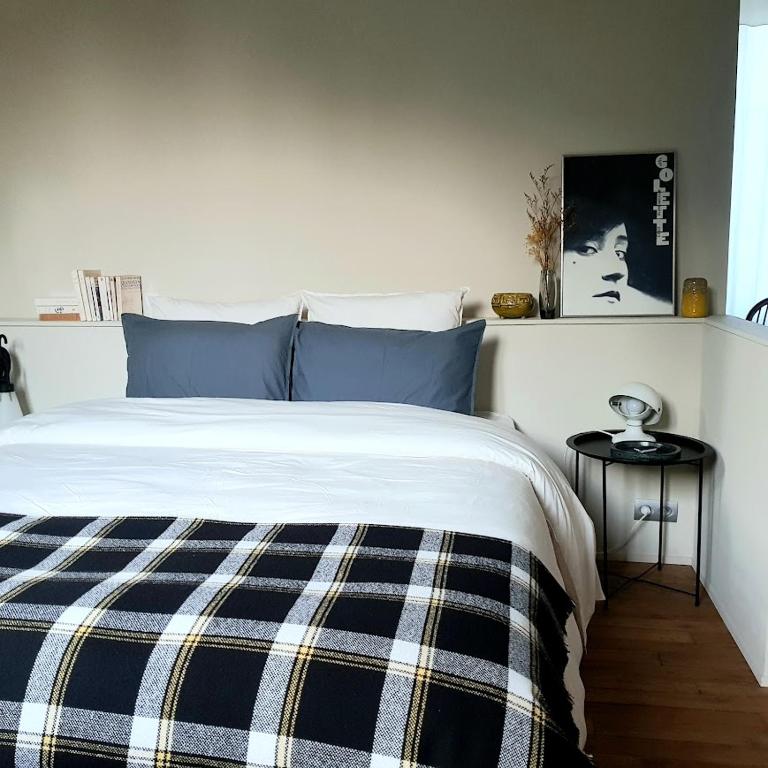 une chambre avec un lit avec une couverture bleue et blanche dans l'établissement la maison haute, à Toucy