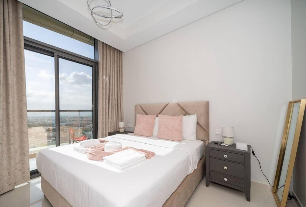 a bedroom with a large bed with a large window at Aykon City 2 bedroom Burj view in Dubai