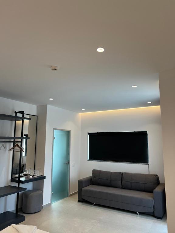 a living room with a couch and a flat screen tv at Adele Hotel Ksamil in Ksamil