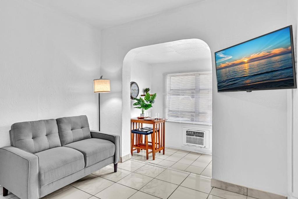 a living room with a couch and a flat screen tv at Downtown Hollywood Beach Blvd Studio Getaway in Hollywood